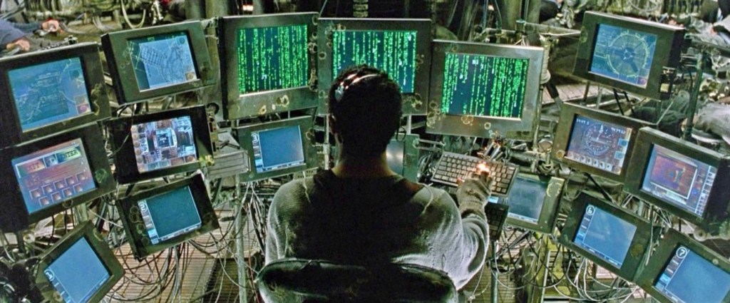 Person surrounded by computers