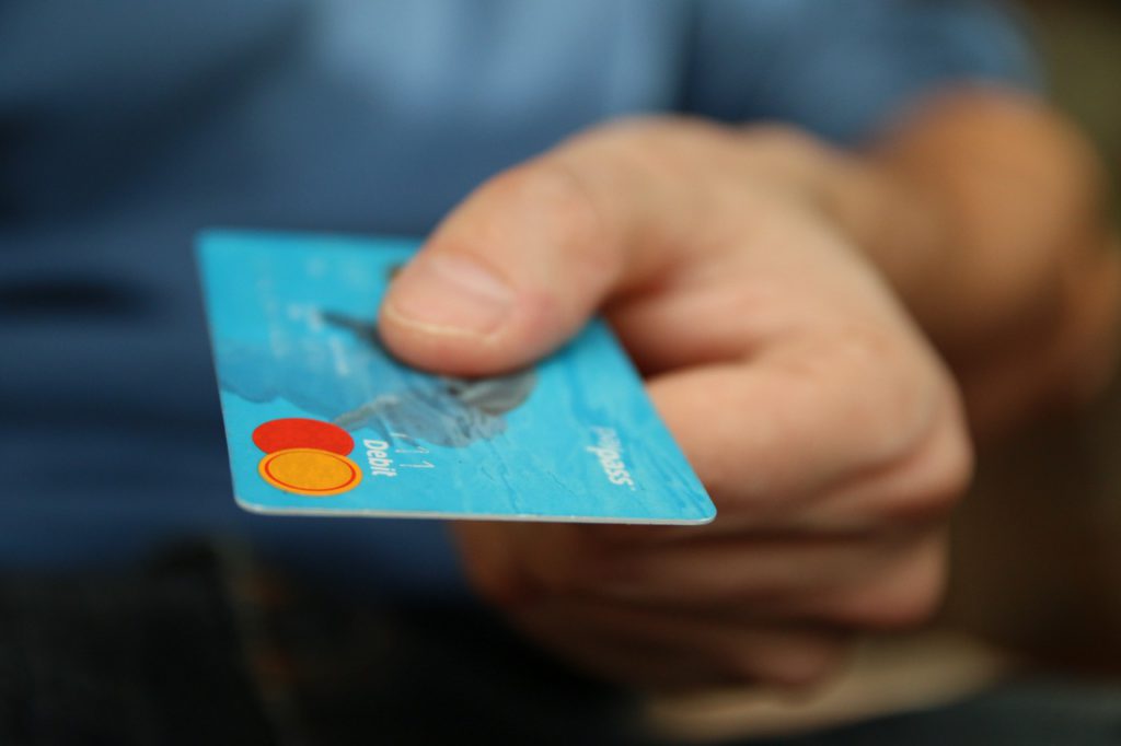 Hand holding a light blue credit card
